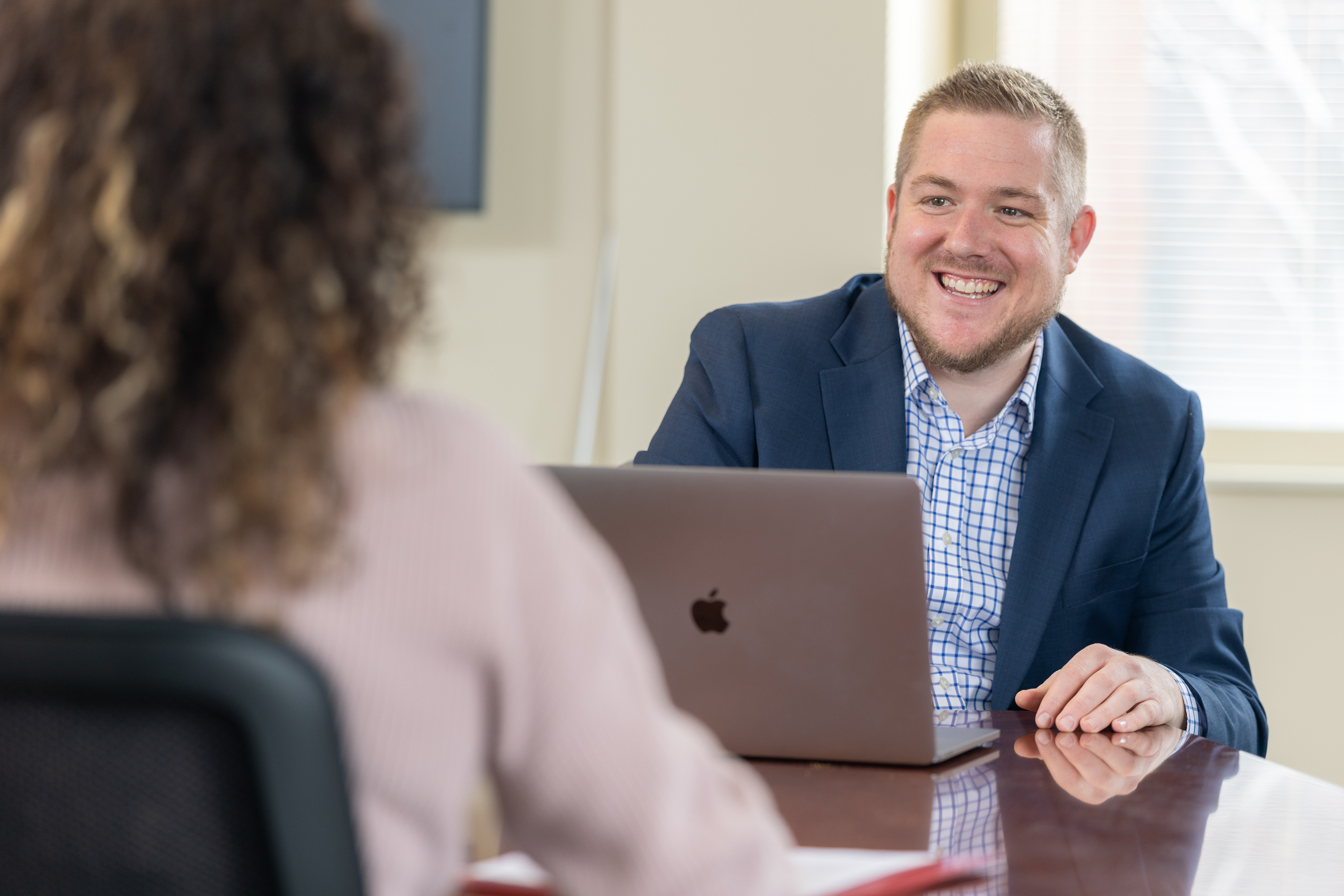 Man with laptop talking to woman