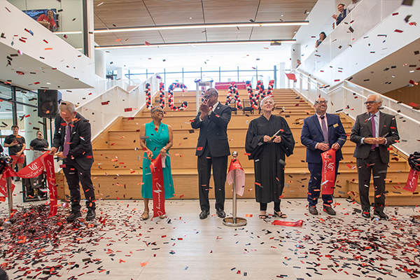 Ribbon cutting at bottom of stairs in the new College of Law Building