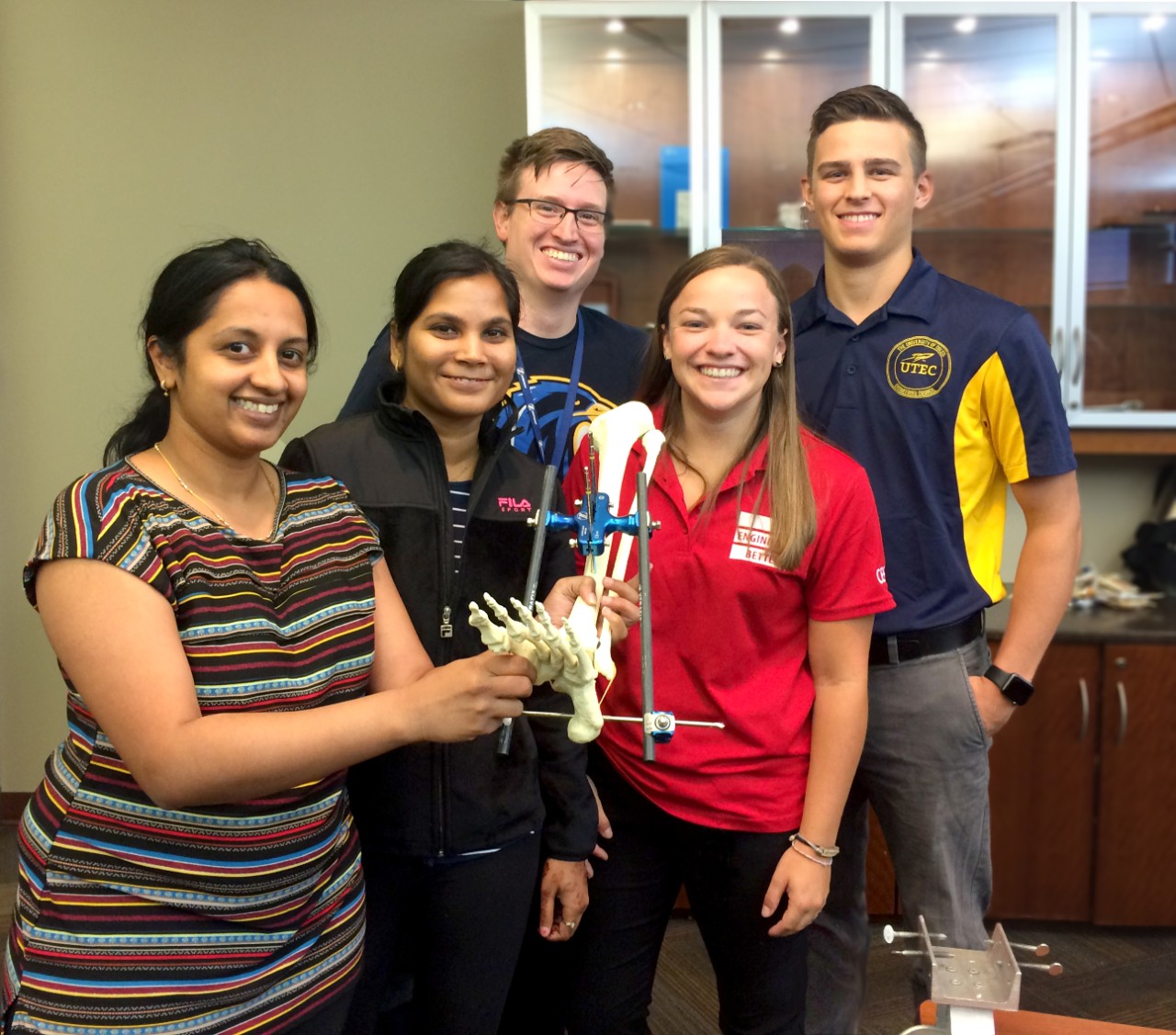 Goodwin with coworkers holding a knee prototype.